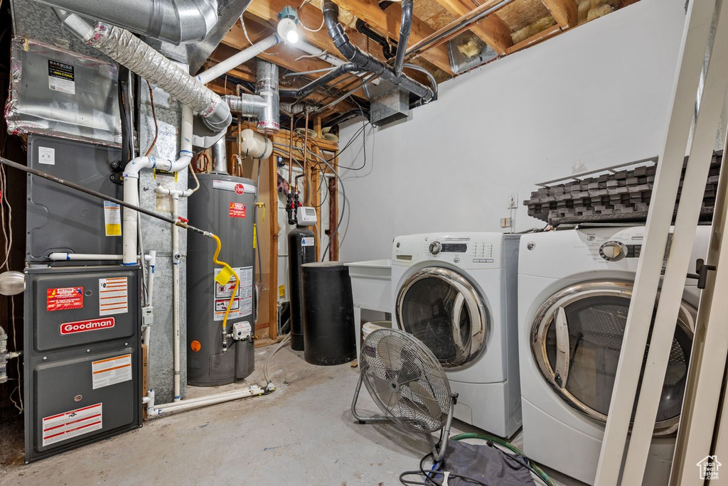 Washroom featuring water heater, washer and dryer, and heating unit