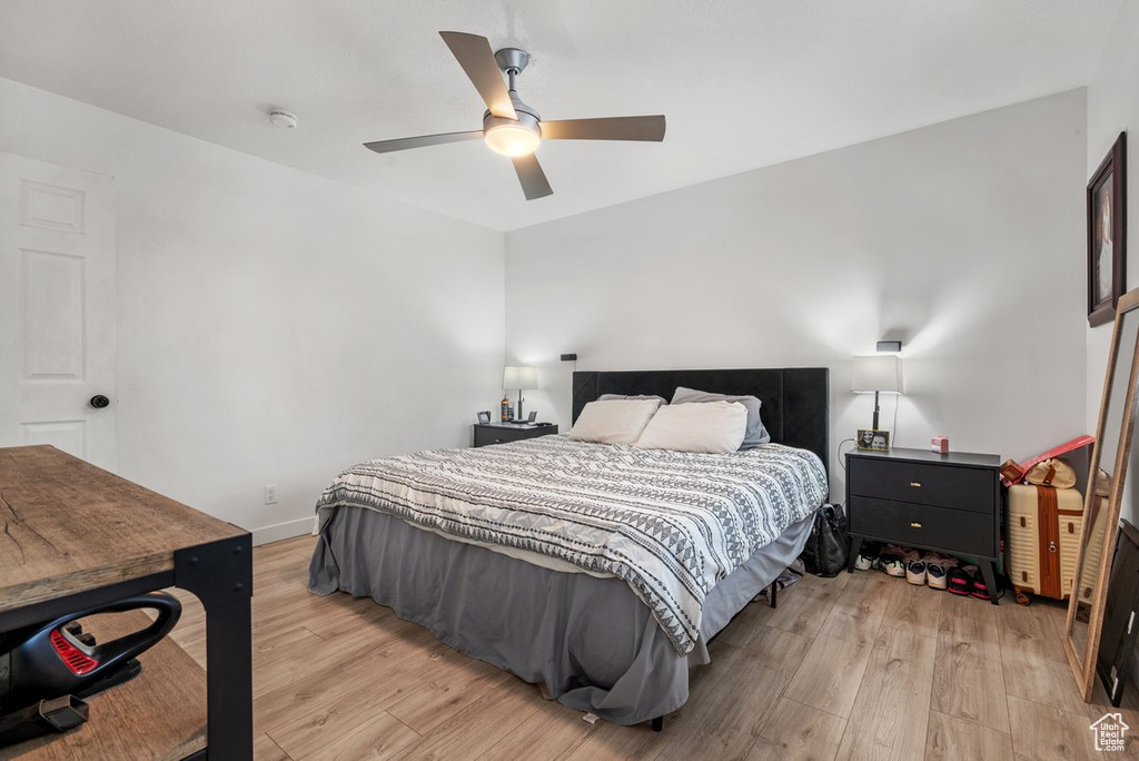 Bedroom featuring light wood-style floors, a ceiling fan, and baseboards
