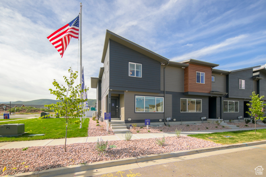 View of front of home with a mountain view and a front yard