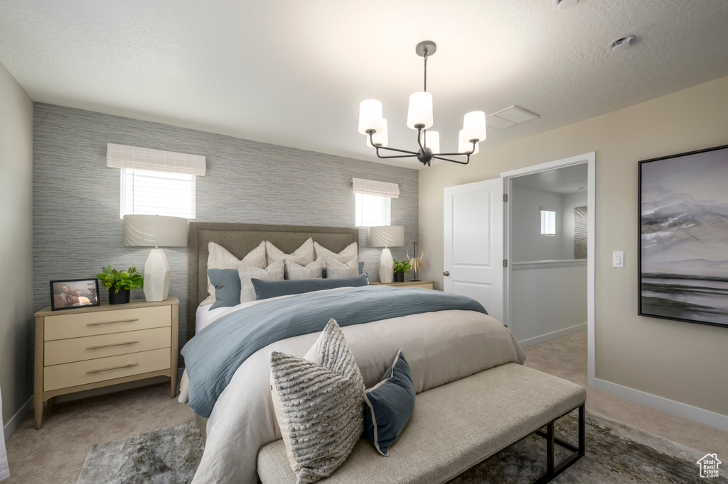 Bedroom featuring a chandelier, light colored carpet, and baseboards