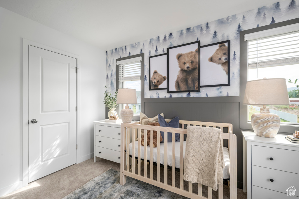 Carpeted bedroom with a nursery area and a desk