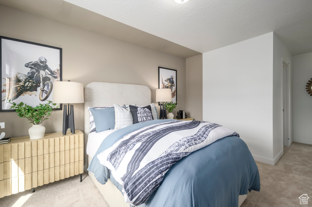 Bedroom with light colored carpet and baseboards