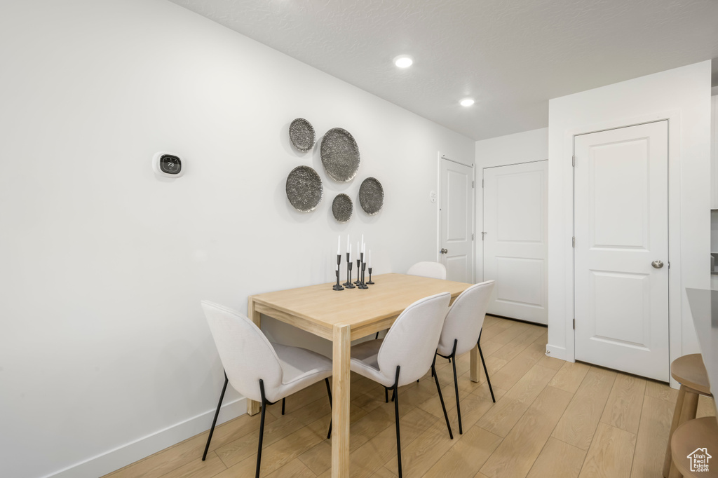 Dining space featuring light wood finished floors, baseboards, and recessed lighting
