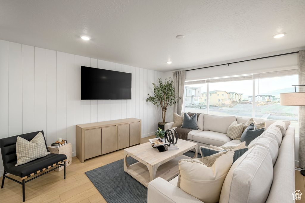 Living area with light wood-style floors and recessed lighting