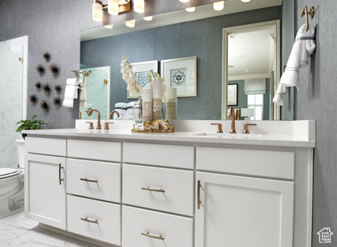 Bathroom with toilet, marble look tile flooring, a shower, double vanity, and crown molding