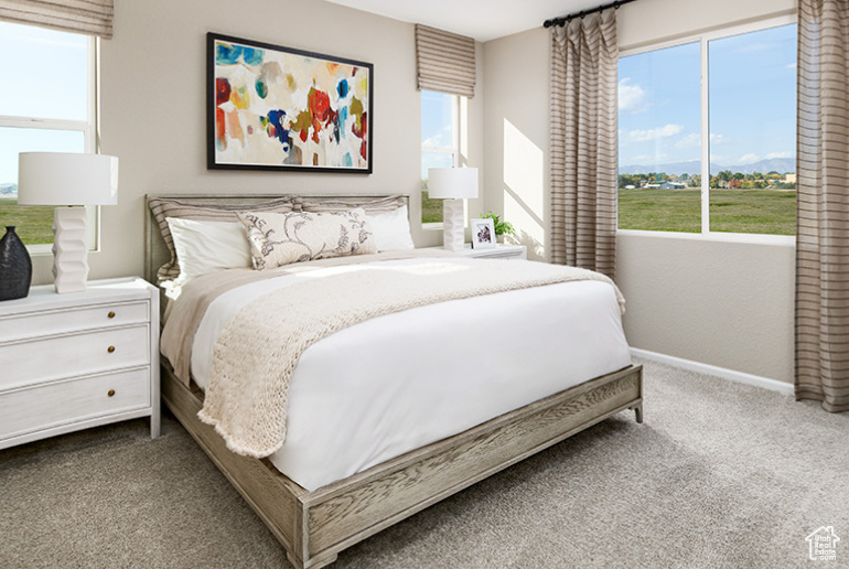 Bedroom featuring carpet and baseboards