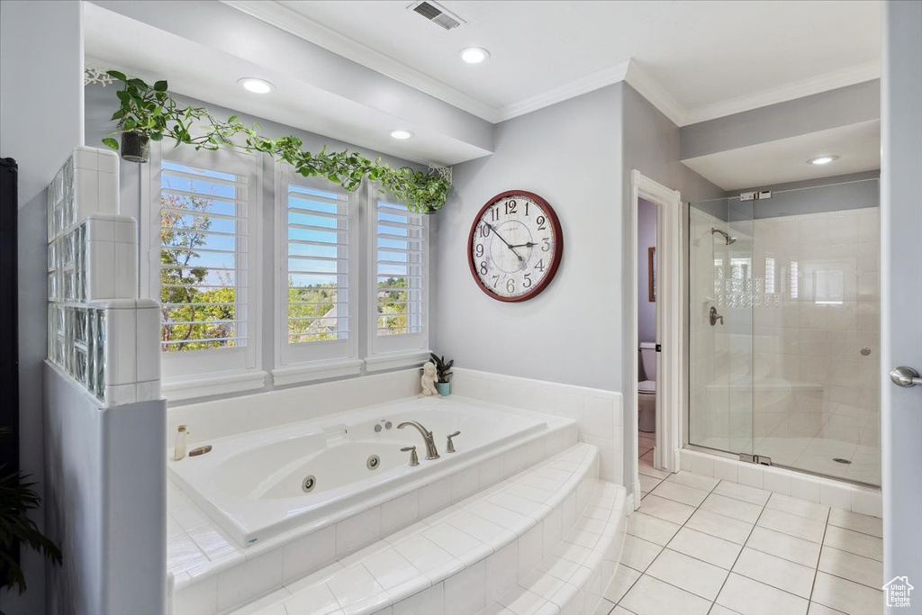 Bathroom with a jetted tub, crown molding, a stall shower, toilet, and tile patterned flooring
