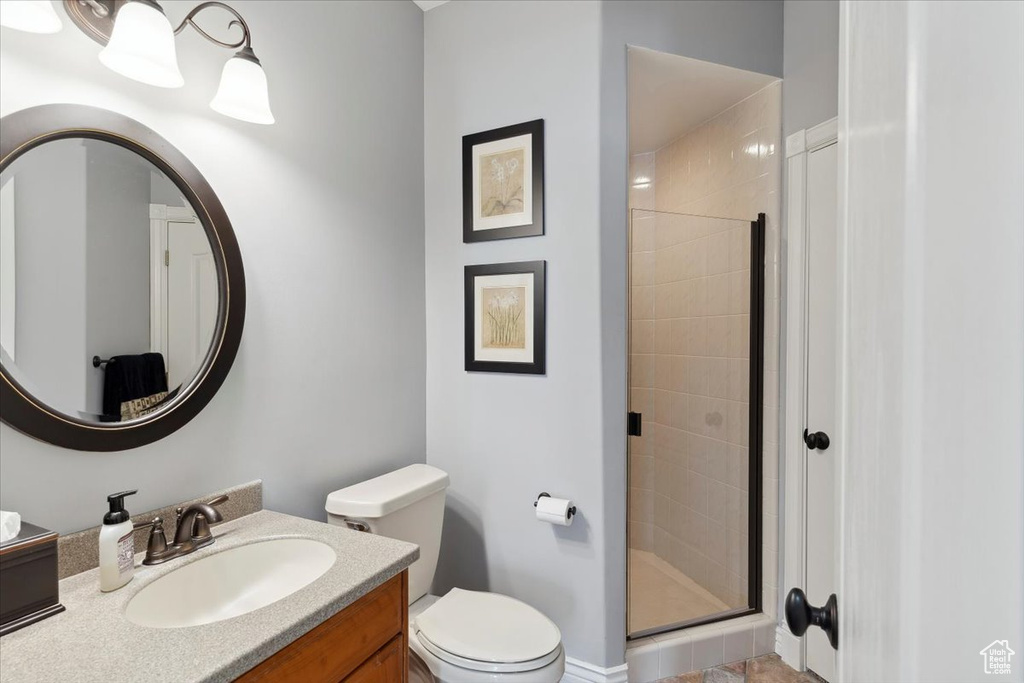Bathroom with a shower stall, vanity, and toilet