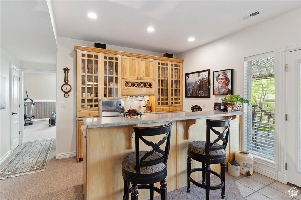 Indoor wet bar with recessed lighting and light colored carpet