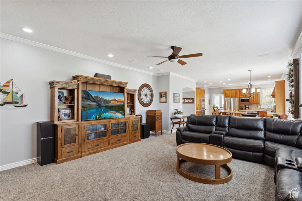 Living room featuring ceiling fan, recessed lighting, a chandelier, baseboards, and light carpet