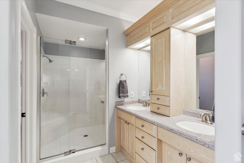 Full bathroom with a shower stall, double vanity, and tile patterned floors