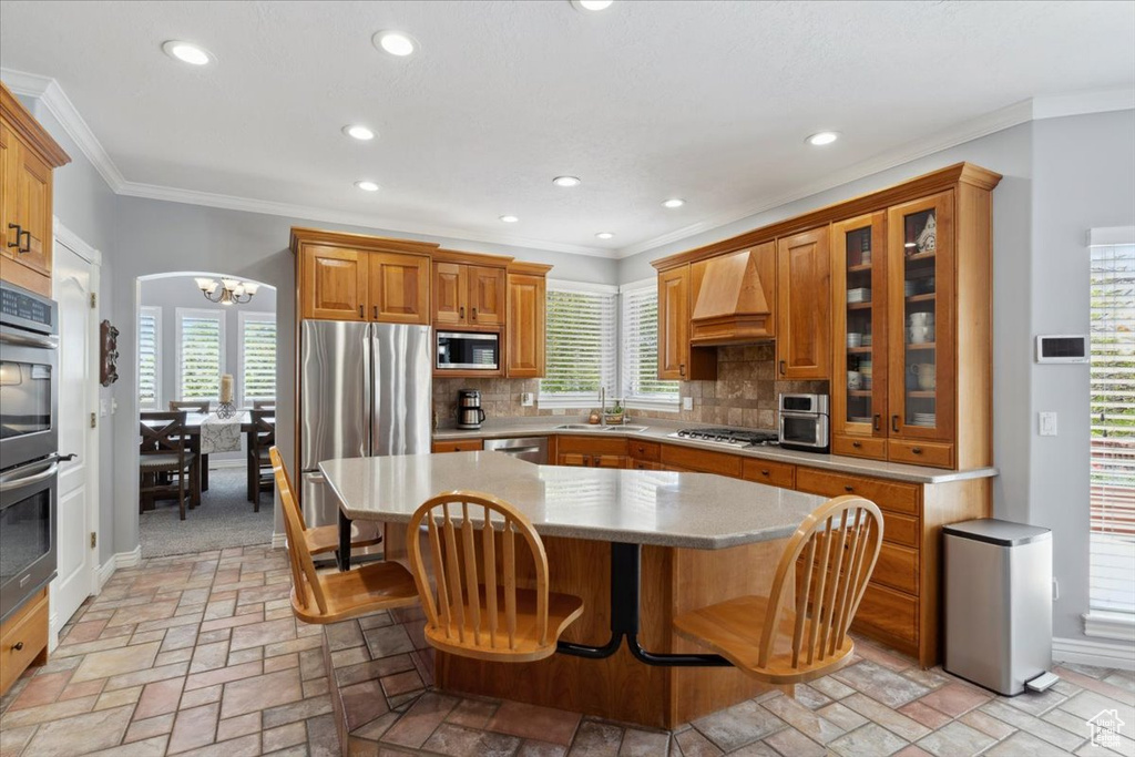 Kitchen with stainless steel appliances, premium range hood, a sink, recessed lighting, and backsplash