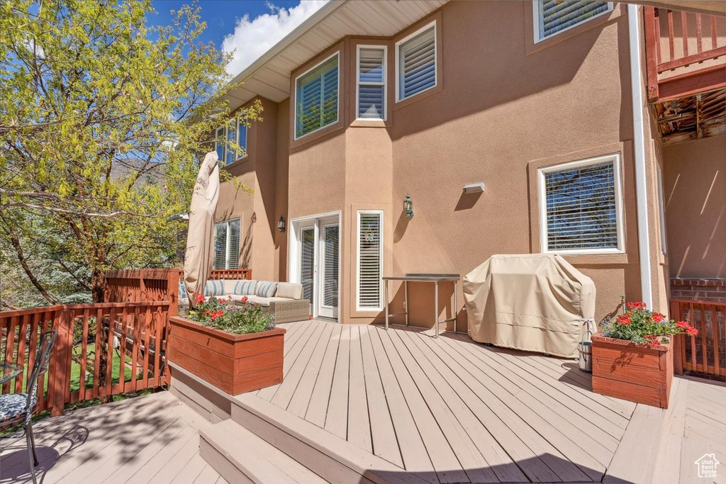 Wooden deck featuring outdoor lounge area and grilling area