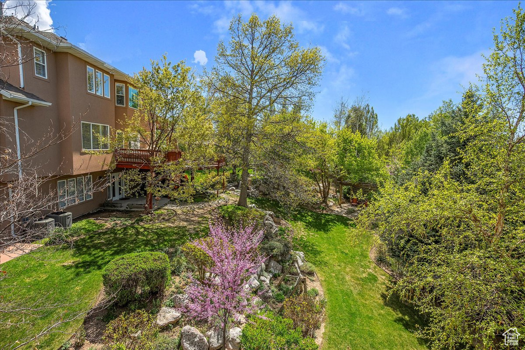 View of grassy yard featuring a wooden deck