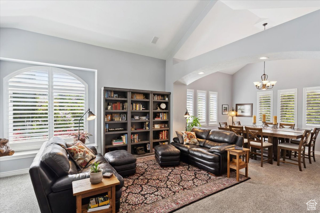 Living area with carpet, vaulted ceiling, and a chandelier