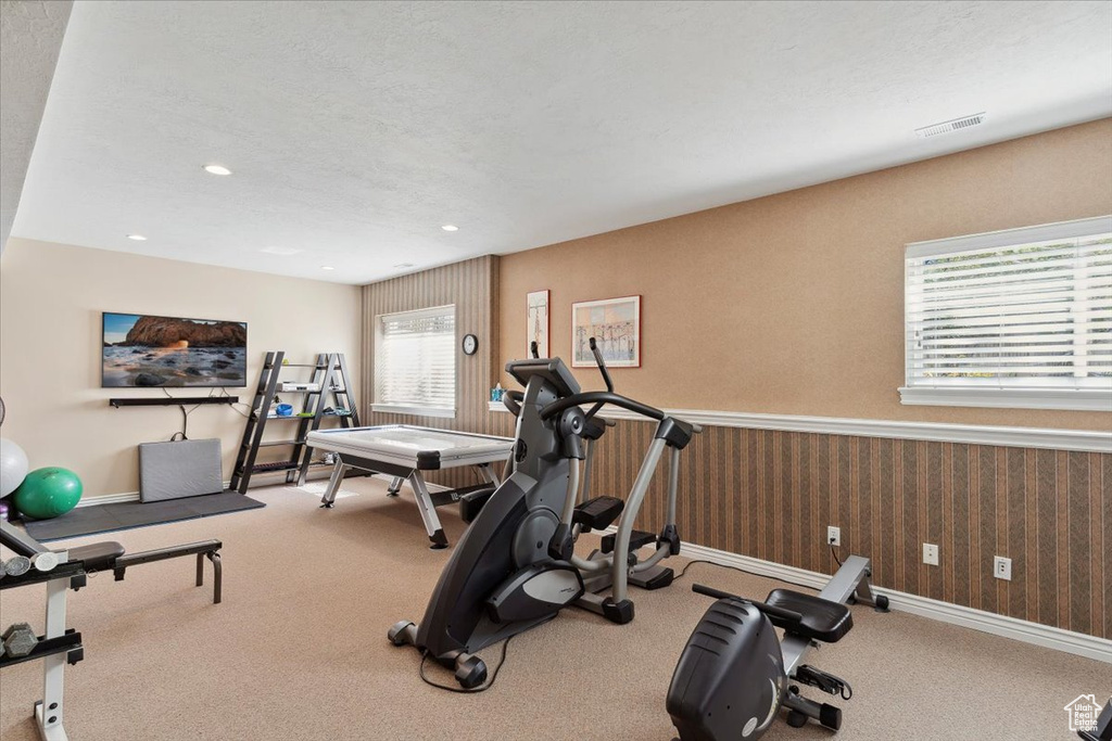 Exercise area featuring carpet, wallpapered walls, baseboards, and recessed lighting