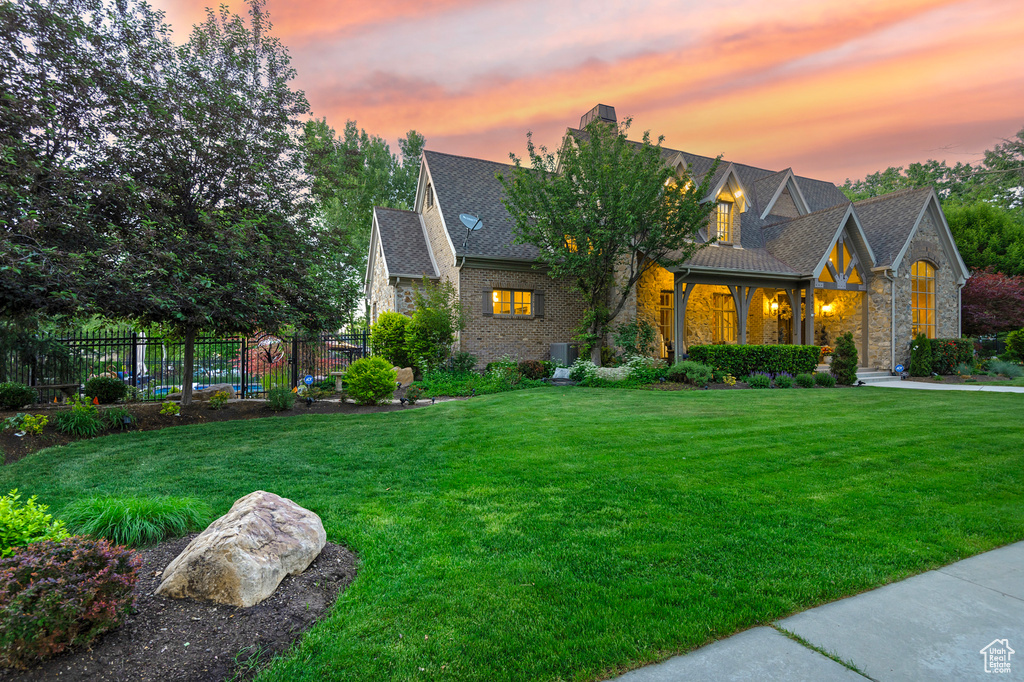 View of front of home featuring a chimney, stone siding, and brick siding