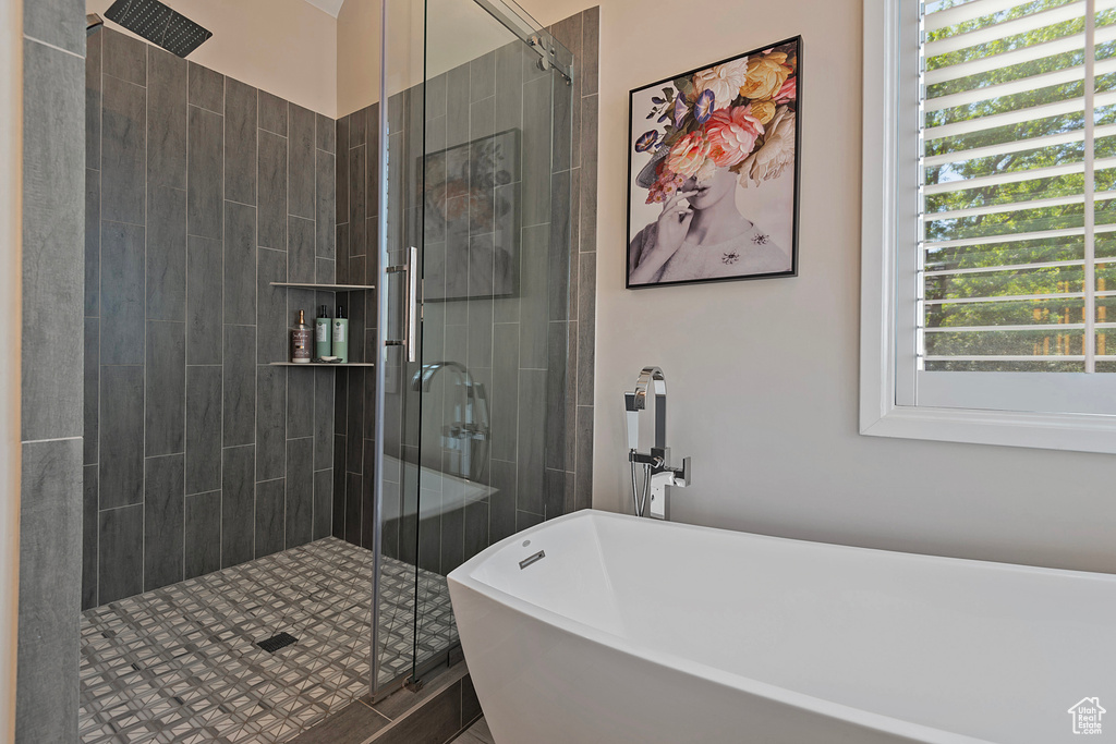 Full bath featuring a soaking tub and a stall shower