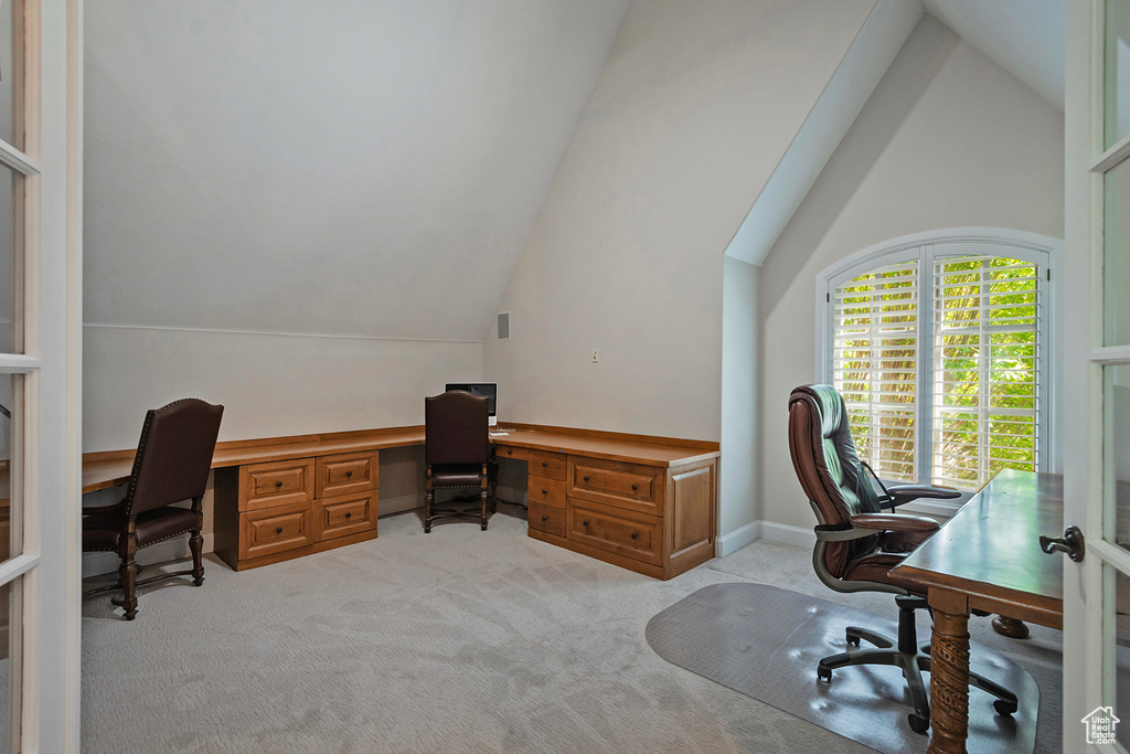 Office space with light colored carpet and lofted ceiling