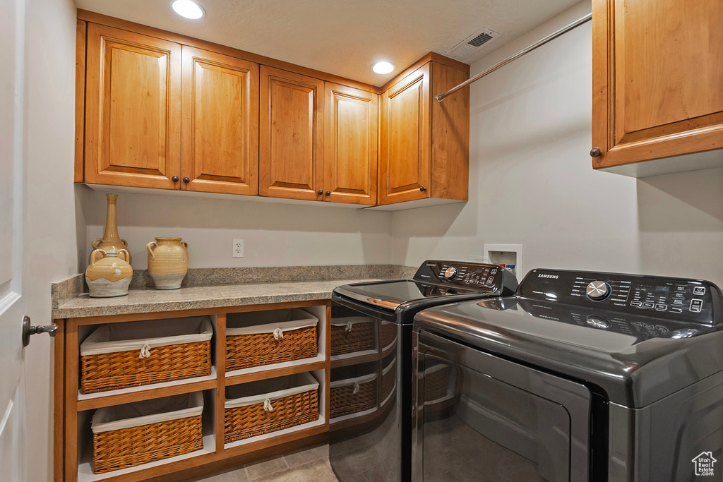 Washroom featuring cabinet space, independent washer and dryer, and recessed lighting