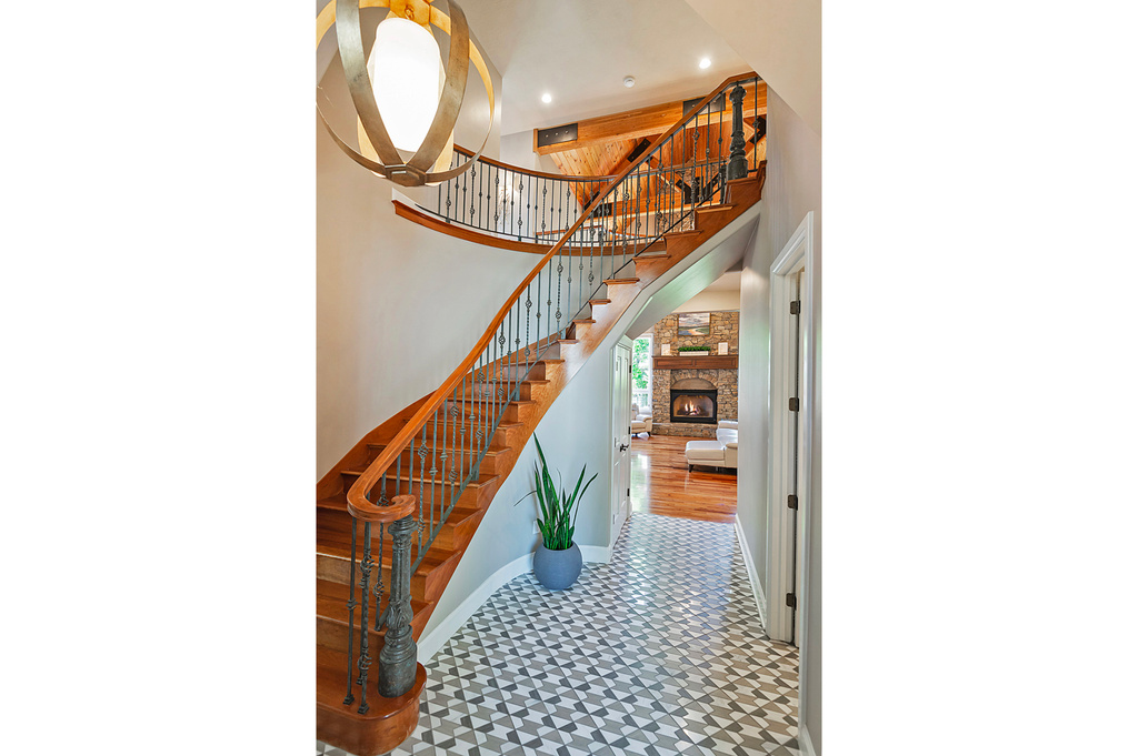 Stairway with tile patterned floors, a high ceiling, baseboards, and a large fireplace