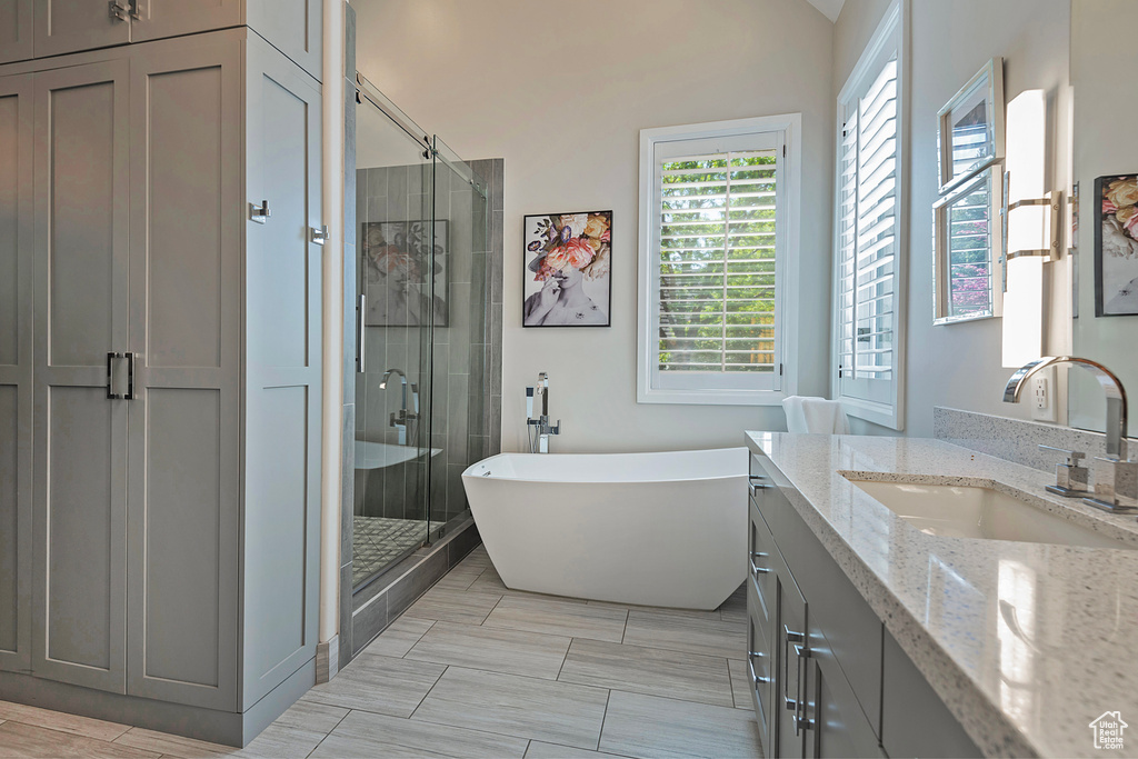 Full bathroom featuring a stall shower, vanity, and a freestanding bath