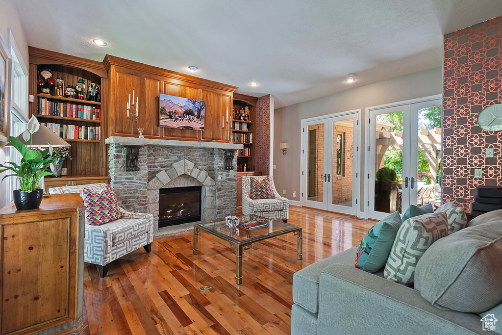 Living area with light wood-style flooring, french doors, a fireplace, recessed lighting, and baseboards