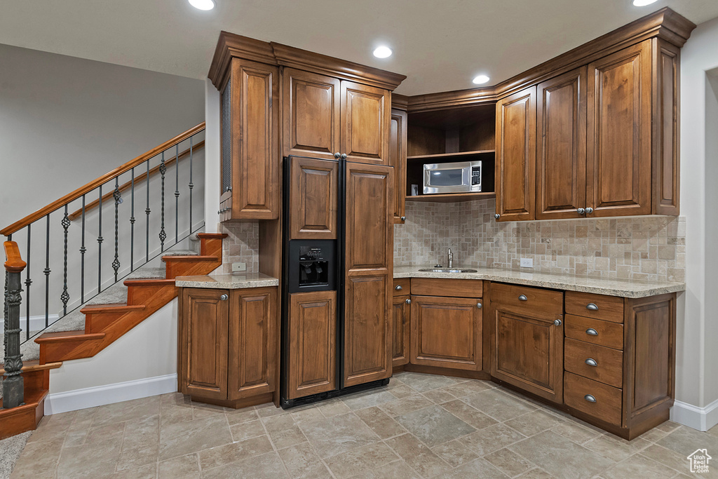 Kitchen featuring a sink, baseboards, tasteful backsplash, and recessed lighting