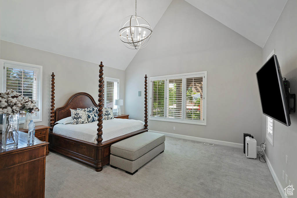 Bedroom with a chandelier, multiple windows, high vaulted ceiling, baseboards, and light colored carpet