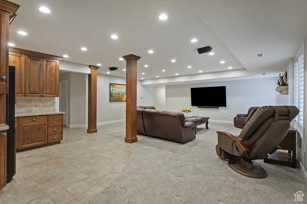 Living area with decorative columns, baseboards, and recessed lighting