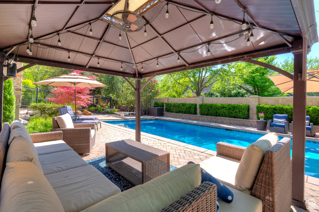 View of swimming pool featuring an outdoor hangout area, a gazebo, a fenced backyard, and a patio area