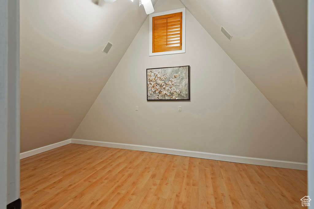 Bonus room featuring baseboards, wood finished floors, and lofted ceiling