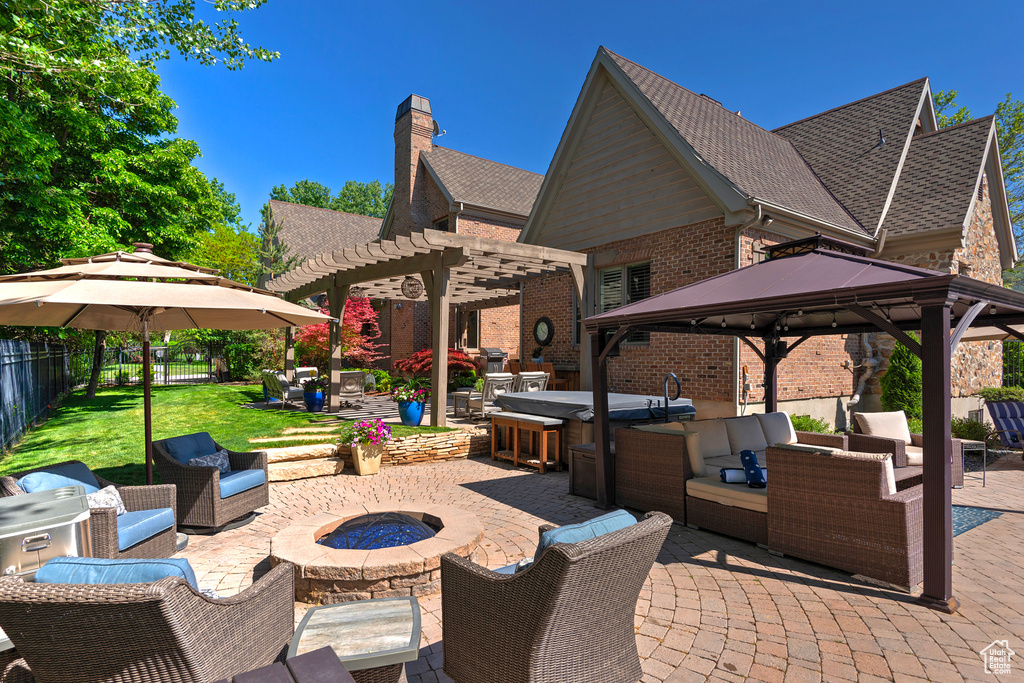 View of patio with an outdoor living space with a fire pit, a pergola, and a gazebo