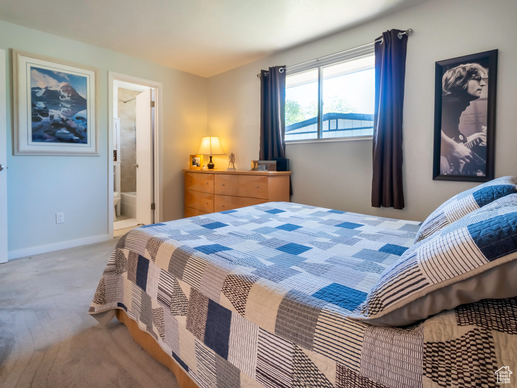 Carpeted bedroom with ensuite bathroom and baseboards