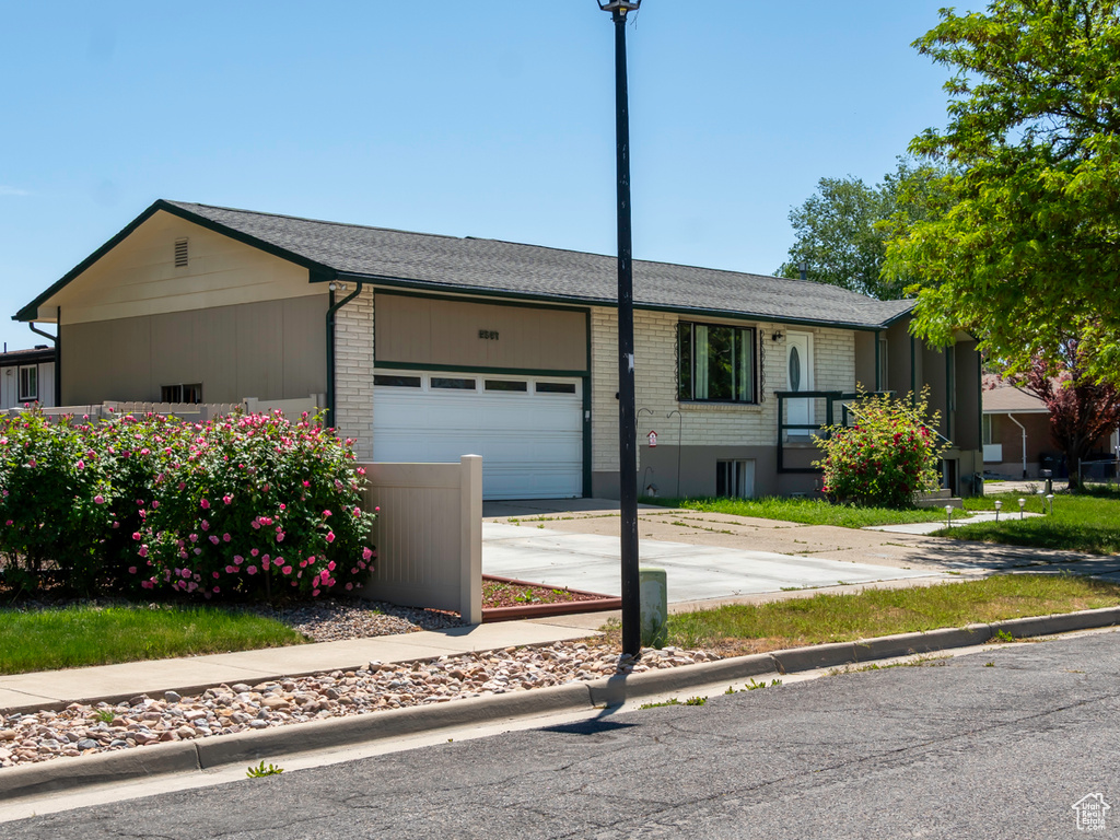 Ranch-style home featuring an attached garage, concrete driveway, and brick siding