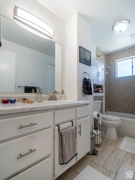 Bathroom featuring vanity, shower / tub combination, toilet, and marble finish floors