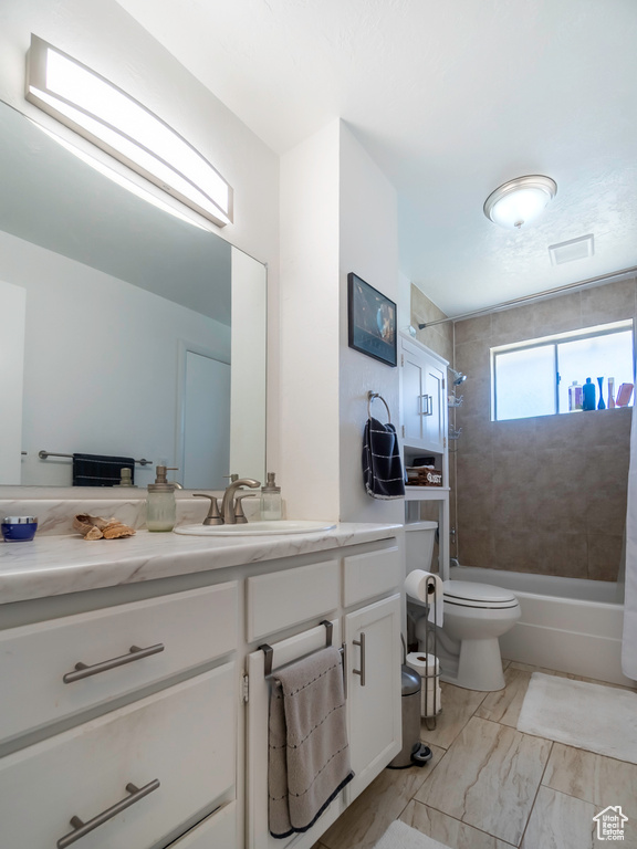 Full bathroom featuring vanity, shower / tub combination, toilet, and marble look tile flooring