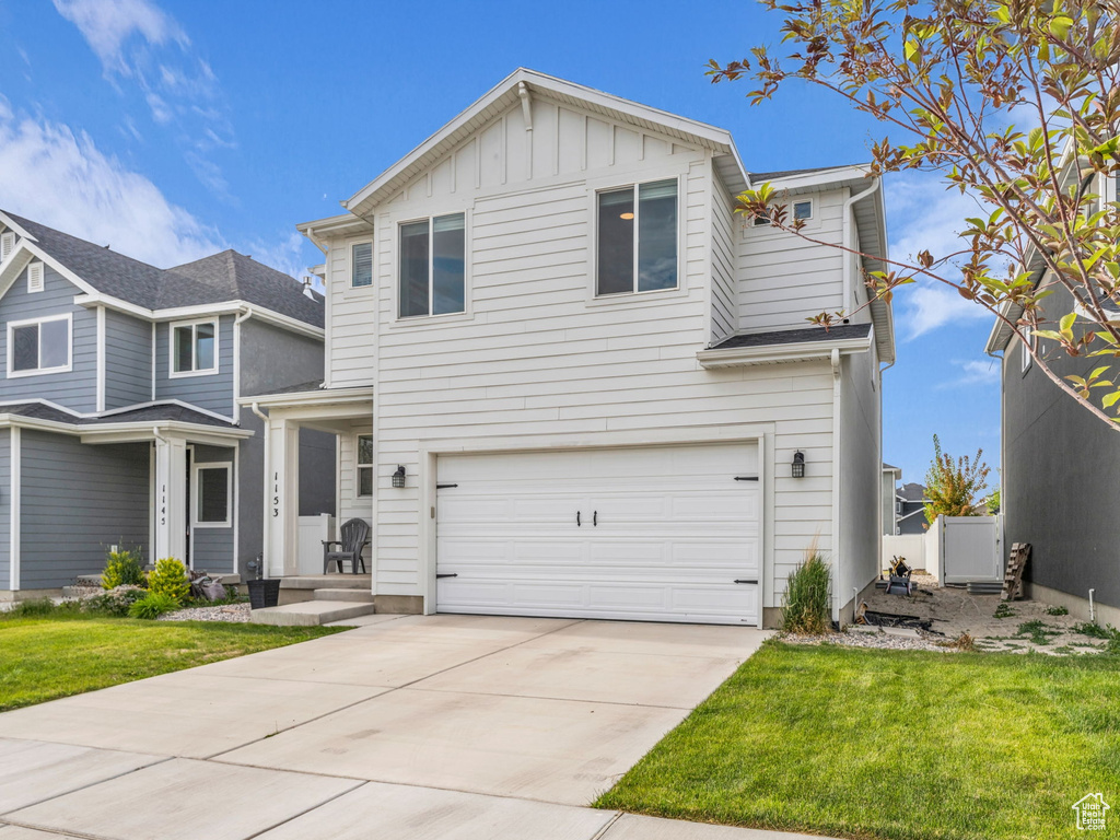 Traditional-style home with a garage, board and batten siding, and concrete driveway