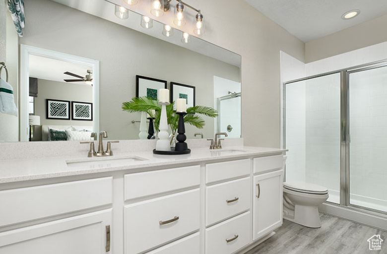 Bathroom with wood finished floors, double vanity, connected bathroom, and a shower stall
