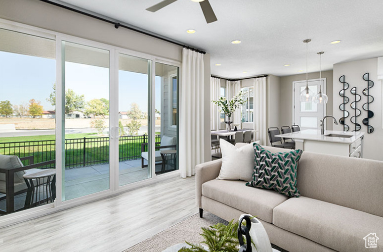 Living room featuring a ceiling fan, wood finished floors, and recessed lighting