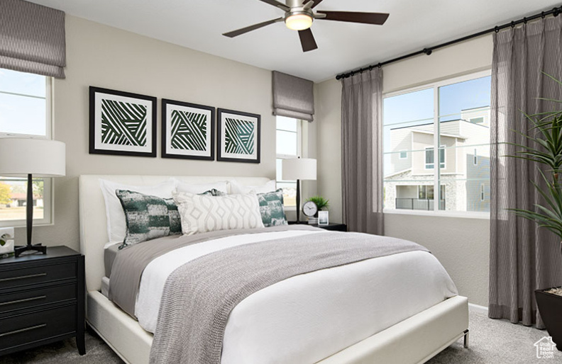 Carpeted bedroom featuring a ceiling fan
