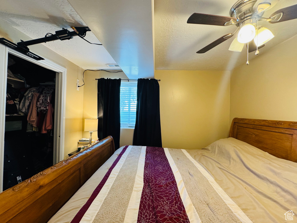 Bedroom featuring ceiling fan and a textured ceiling