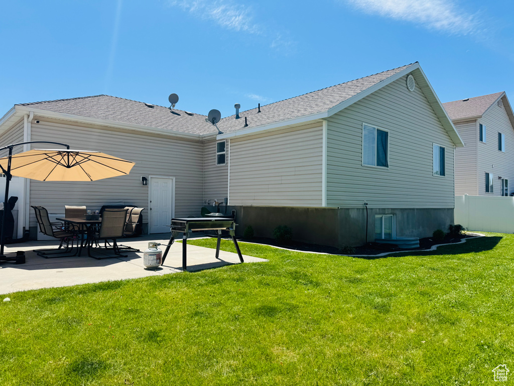 Back of house with a patio area and a shingled roof