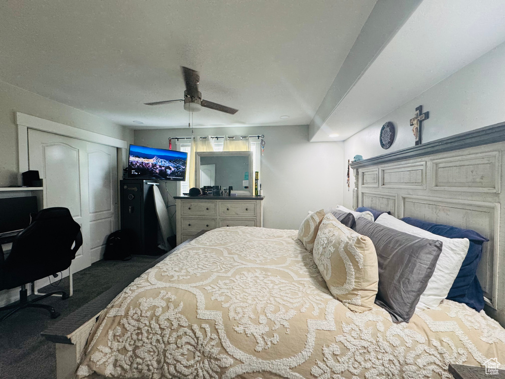 Carpeted bedroom featuring a ceiling fan and a desk