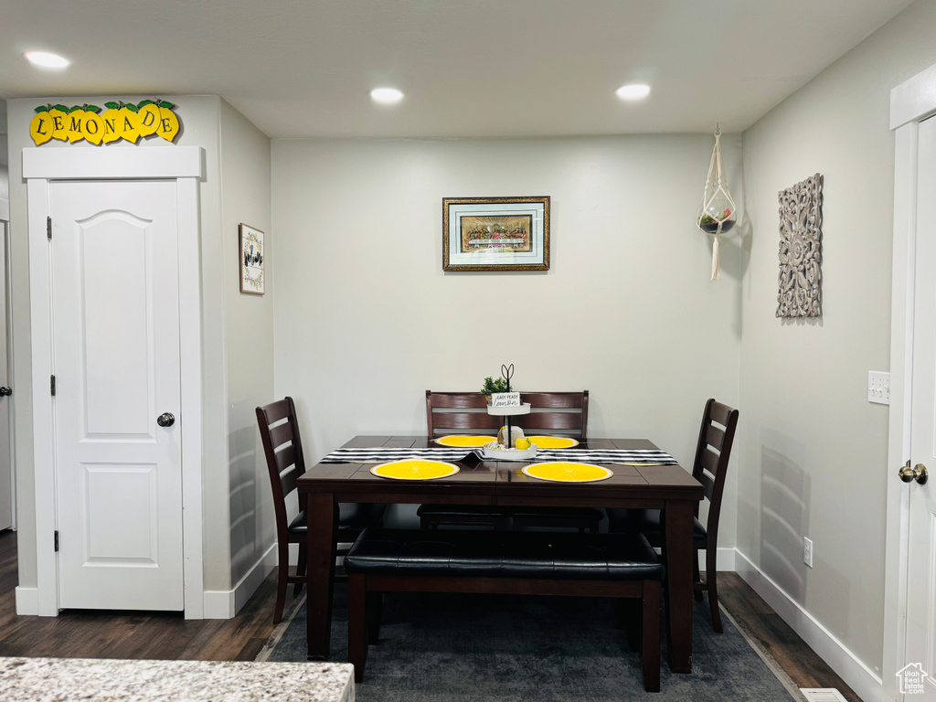 Dining room with dark wood finished floors, recessed lighting, and baseboards