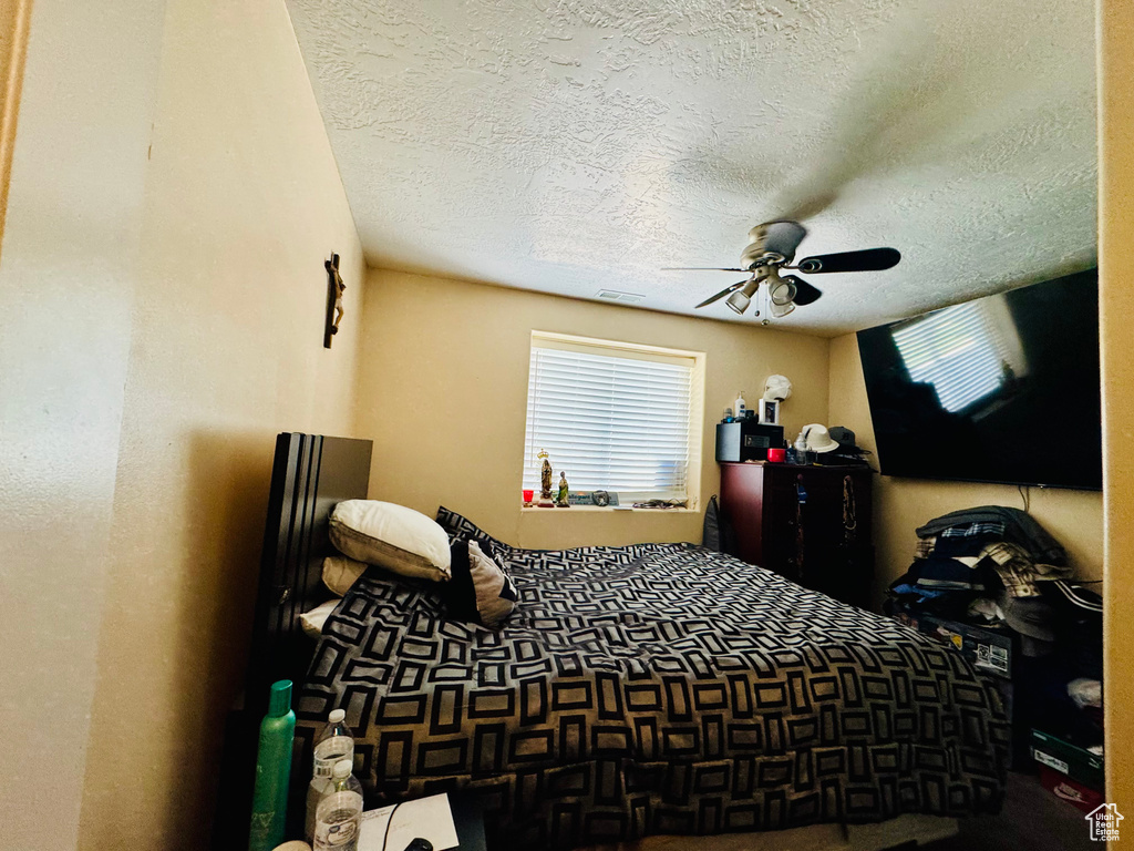 Bedroom featuring a textured ceiling and a ceiling fan
