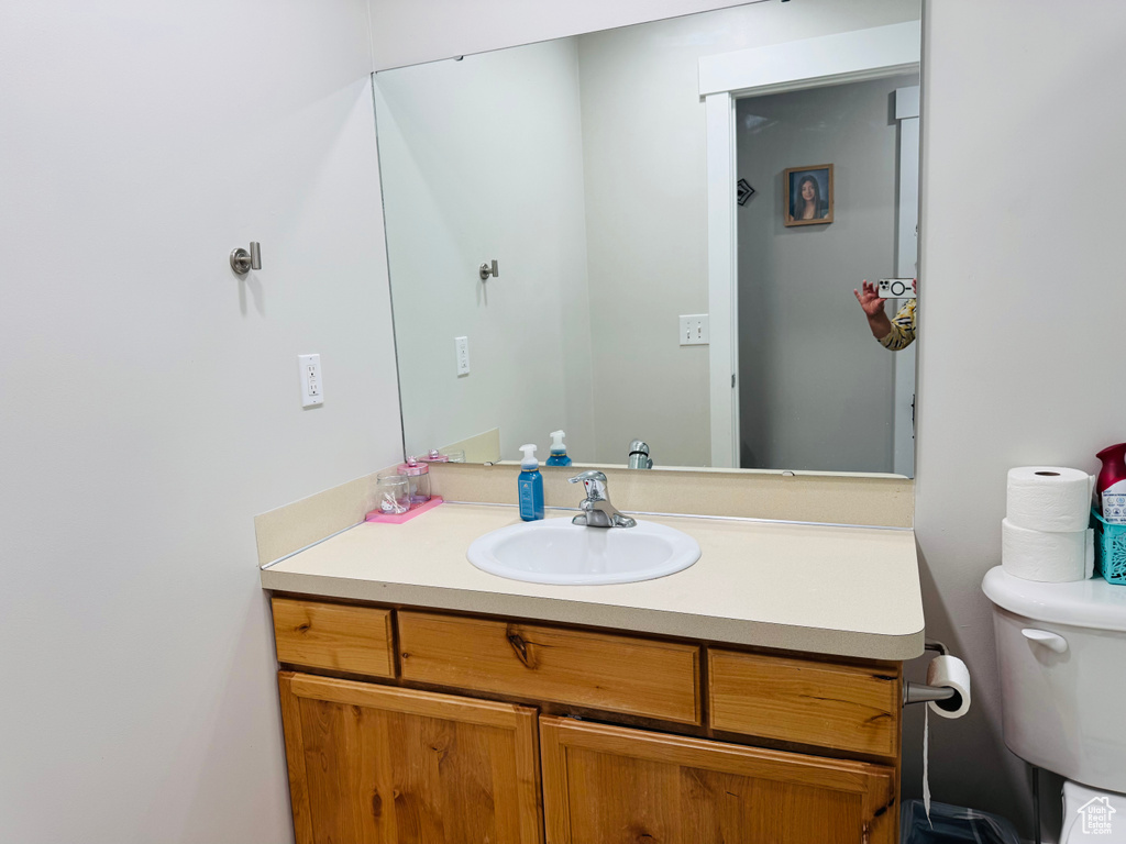 Half bathroom featuring vanity and toilet