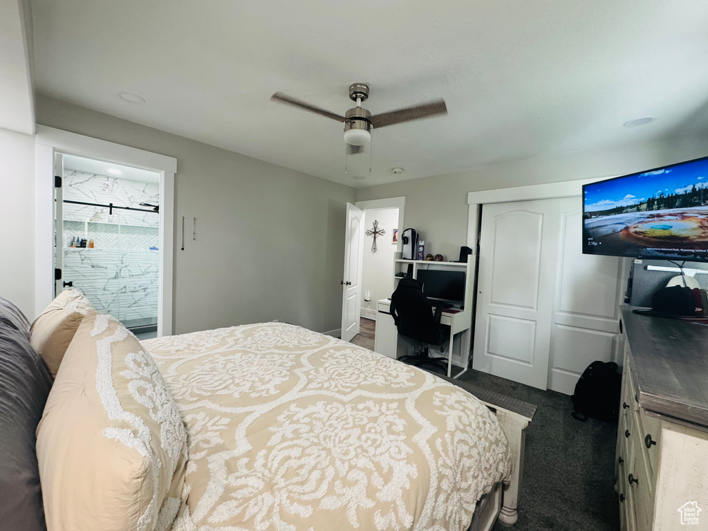 Bedroom with a closet, an office area, a ceiling fan, and dark colored carpet