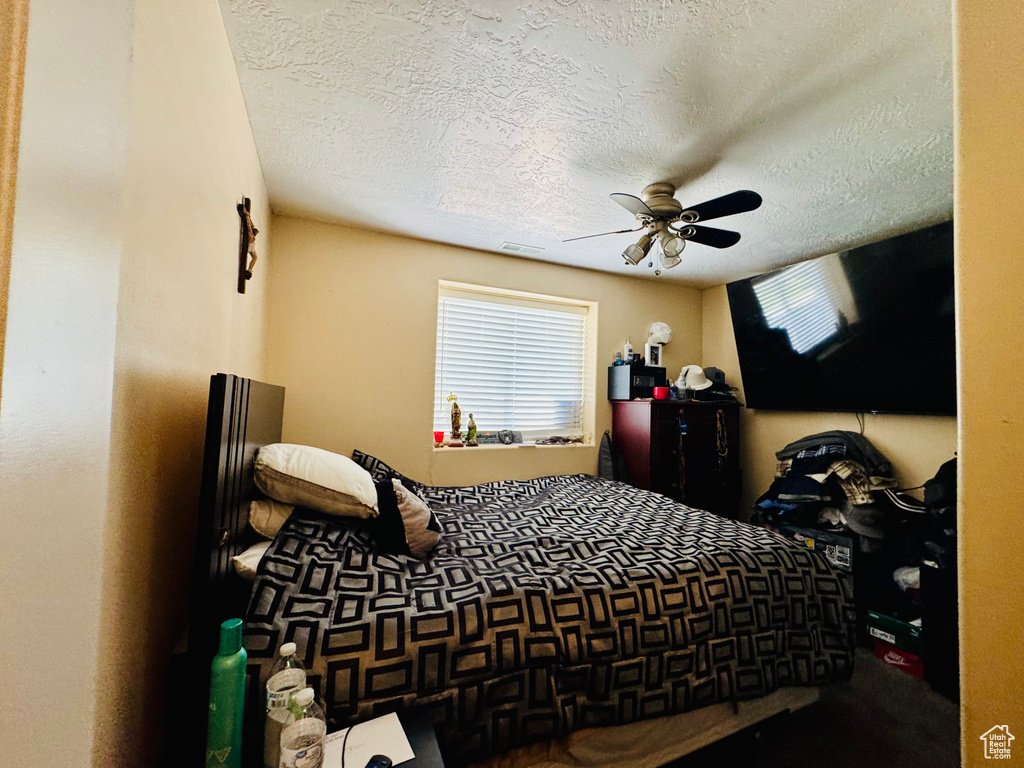 Bedroom featuring a textured ceiling and a ceiling fan