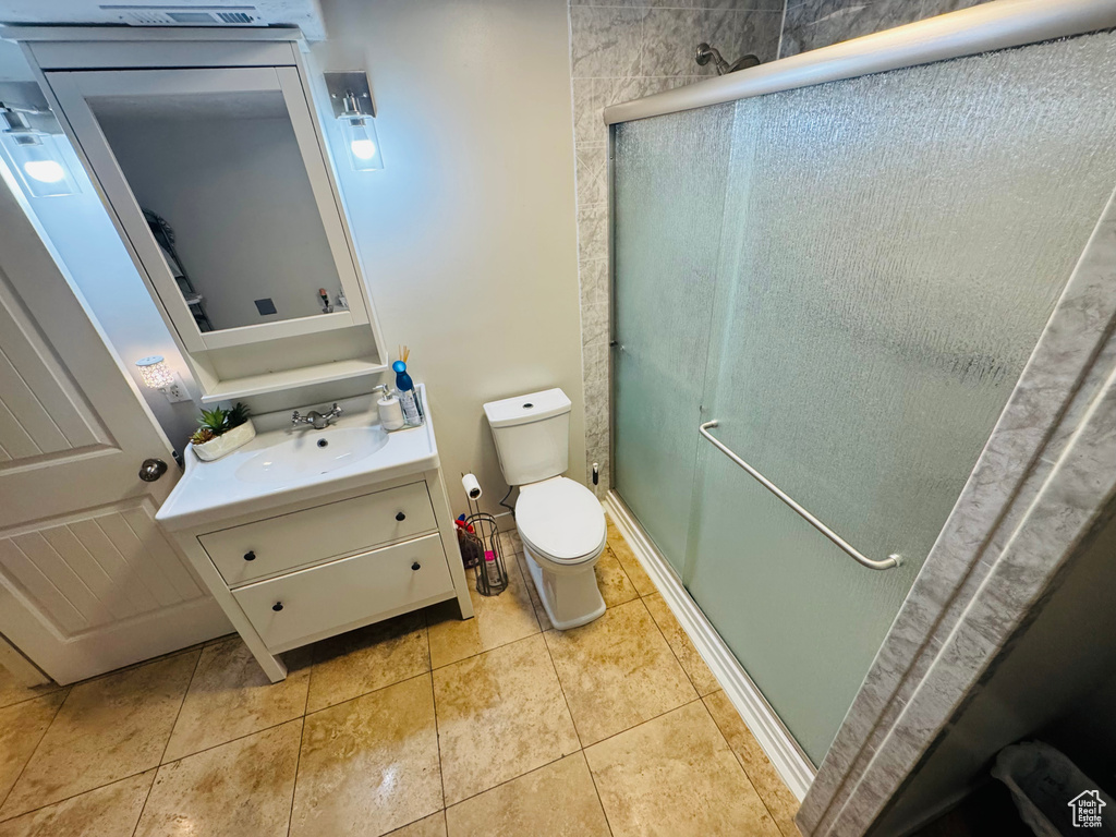 Full bathroom featuring vanity, a shower stall, toilet, and tile patterned flooring
